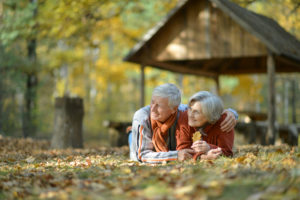 Older couple lying on the lawn on a fall day